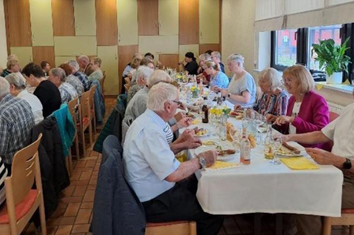 Fronleichnam 2026 - Fest der Begegnung im Jugendheim Merchweiler - Gäste an langen Tischen beim Essen