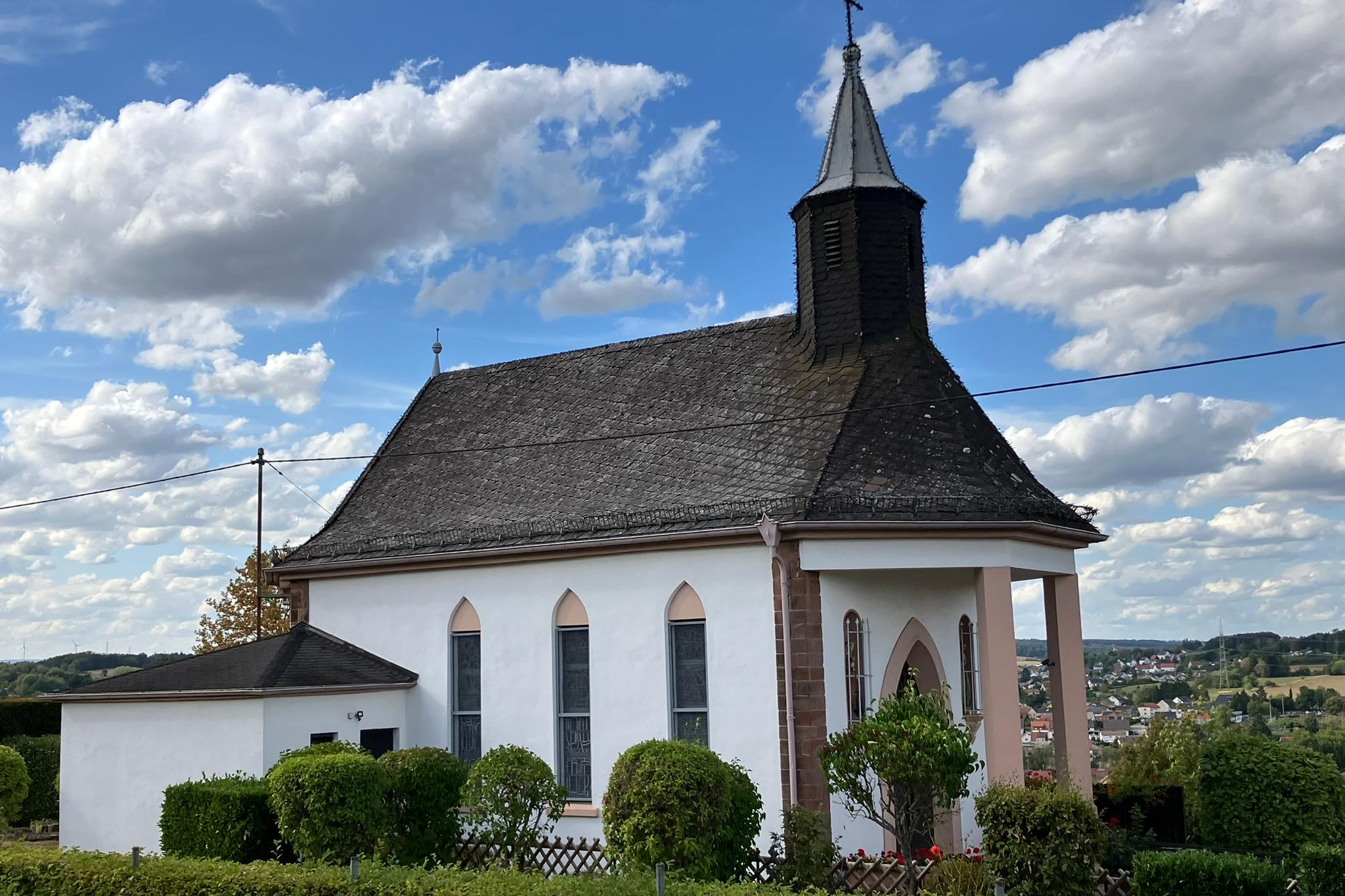 Kapelle Maria Hilf am Rosengarten in Wemmetsweiler, aufgenommen von vorne links, bei schönem Wetter