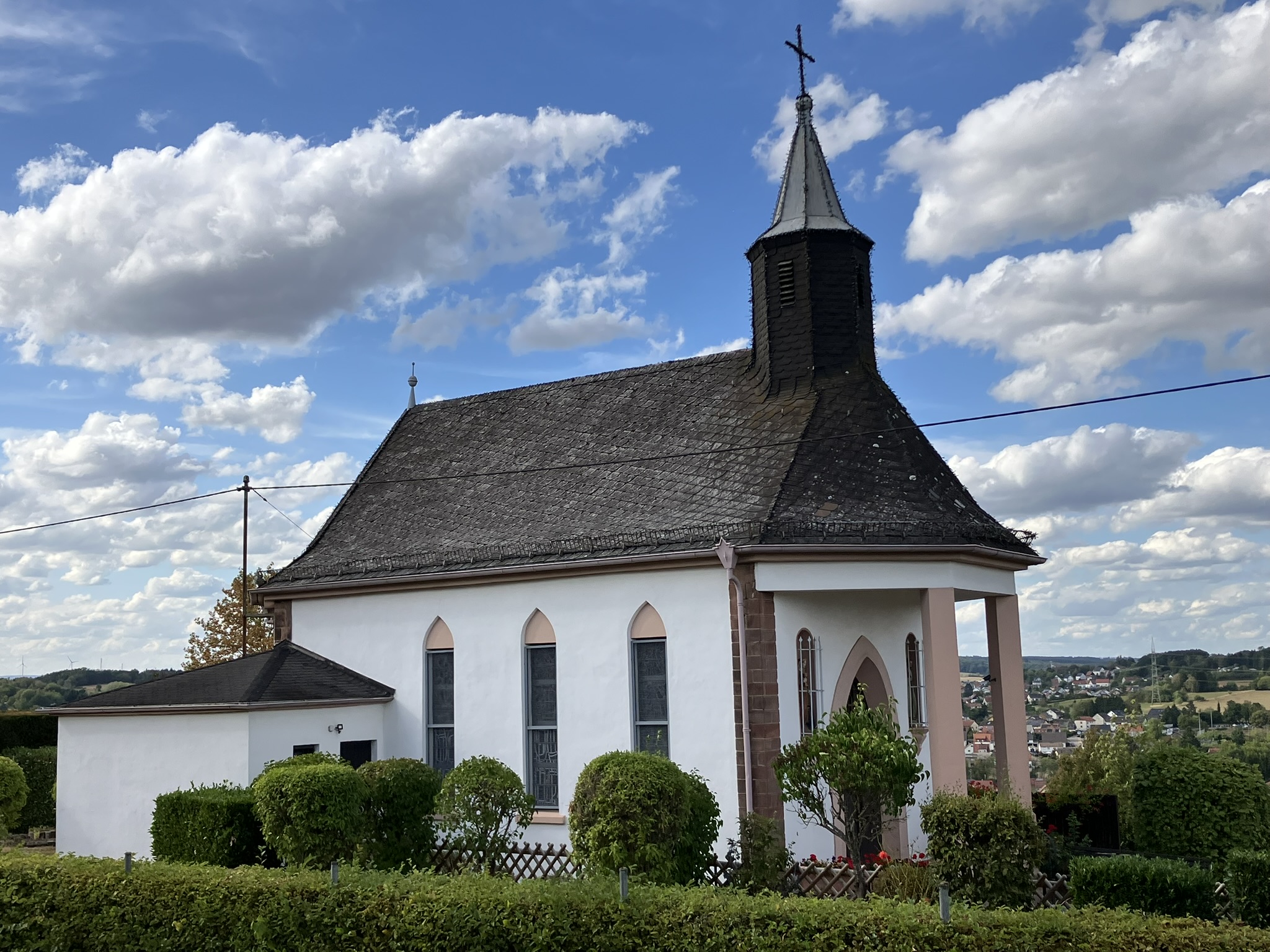Kapelle Maria Hilf am Rosengarten in Wemmetsweiler, aufgenommen von vorne links, bei schönem Wetter