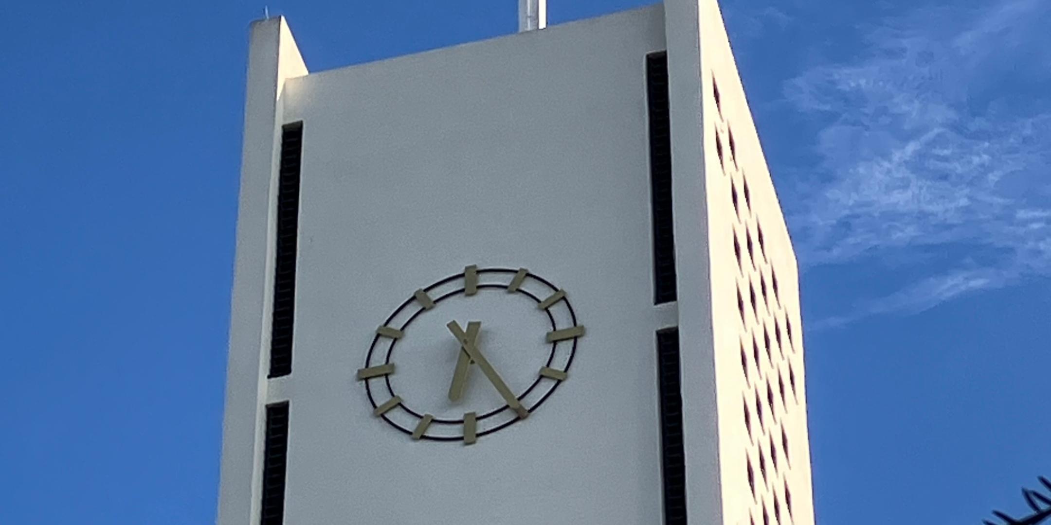 Kirchturm der Kirche Hl. Rosenkranzkönigin Merchweiler. Man sieht den oberen Teil mit der Uhr und dem Kreuz.
