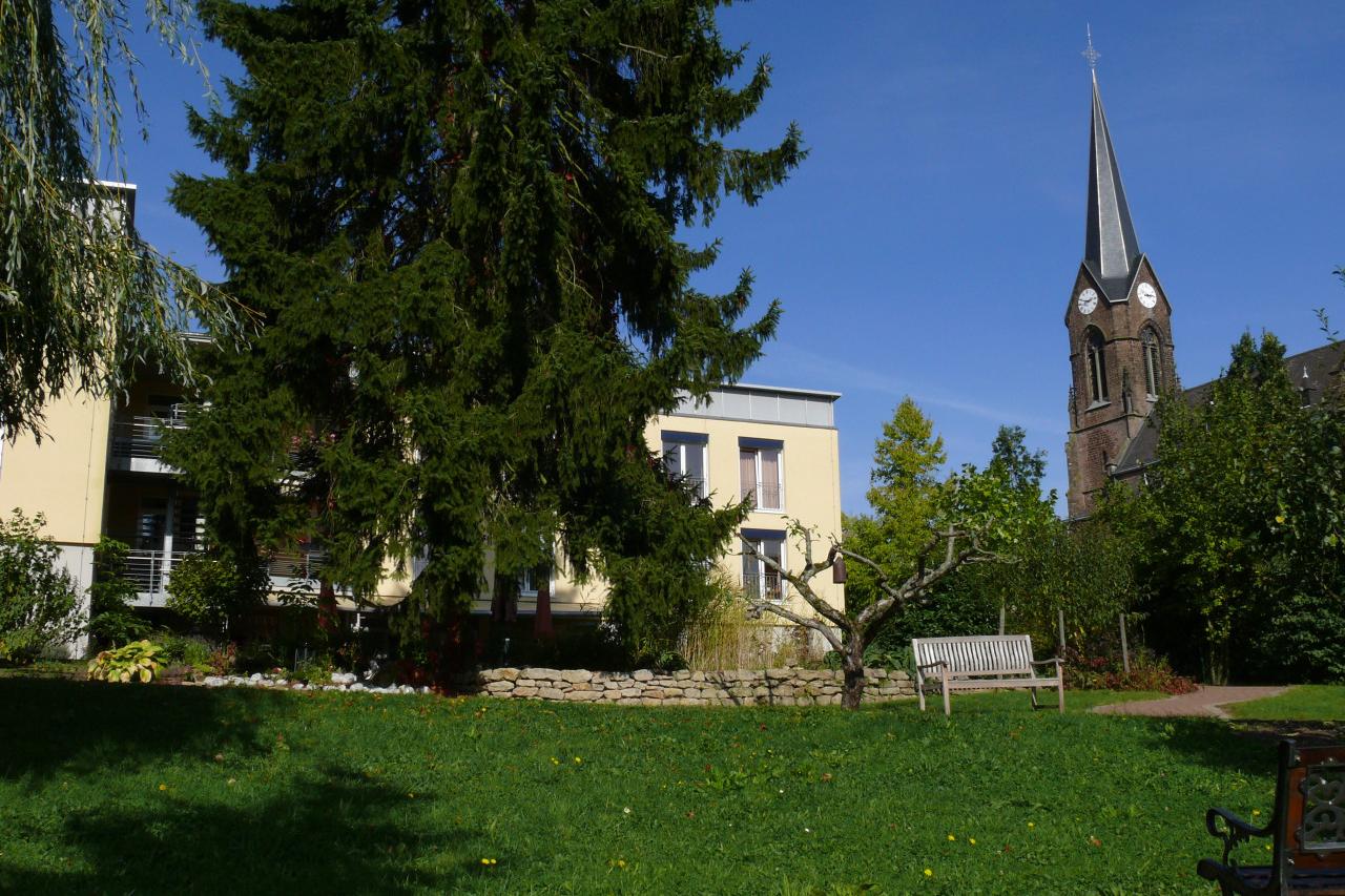 SeniorenHaus Immaculata - Gartenansicht mit Kirche St. Michael auf der rechten Seite