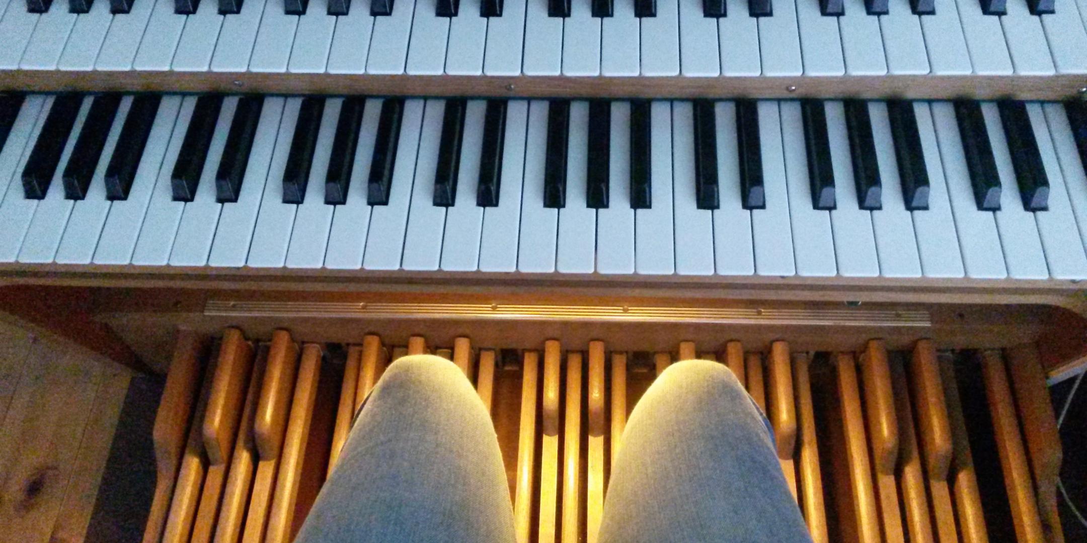 Das bild zeigt zwei Manuale und die Fußpedale einer Orgel. Im vordergrund kann man die Knie des Organisten sehen. (c) Anna Rether | pfarrbriefservice.de Das bild zeigt zwei Manuale und die Fußpedale einer Orgel. Im vordergrund kann man die Knie des Organisten sehen.